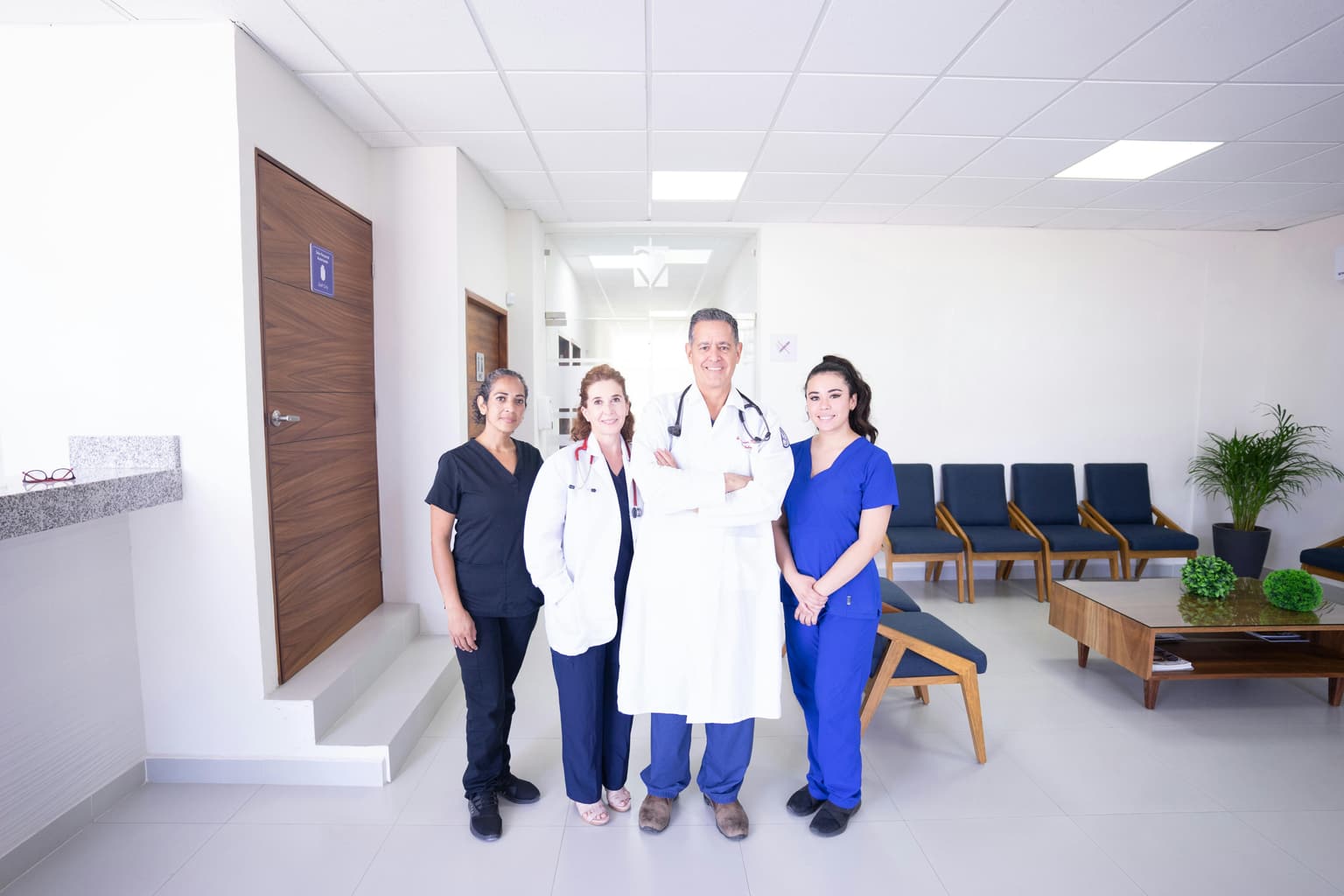 A doctor and three clinic staff standing together in a partner clinic reception