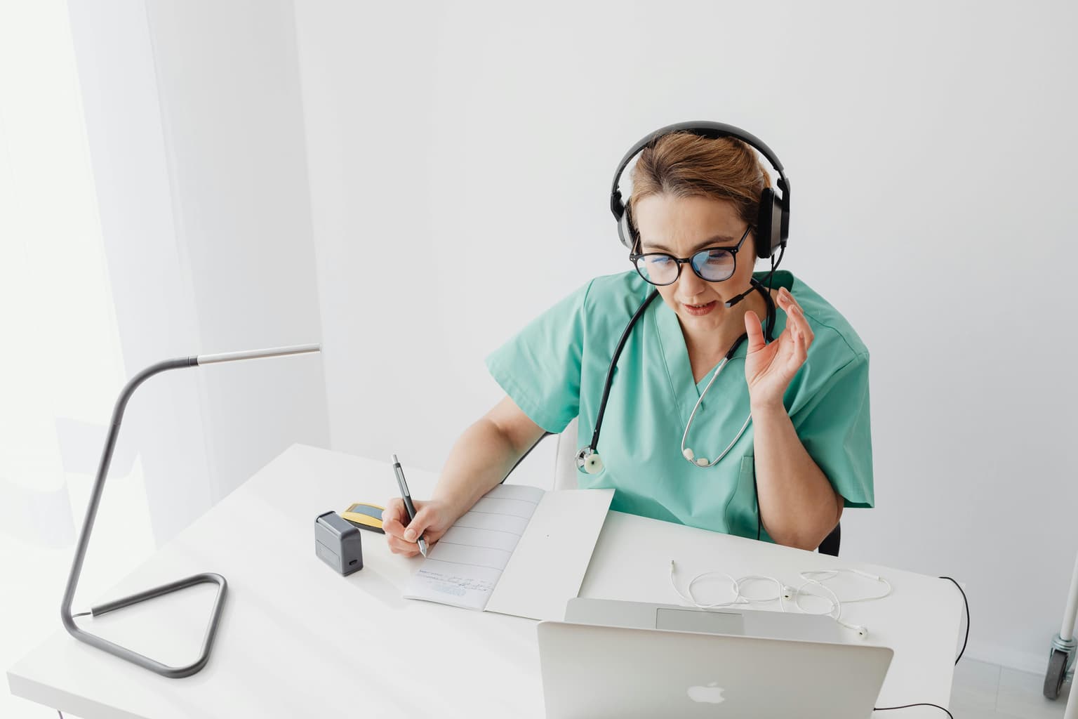 A patient coordinator wearing a headset preparing a cost estimate at her desk